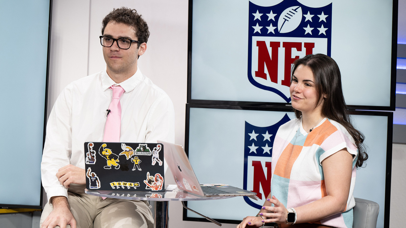 University of Iowa students Cole Krueger and Elise Gan host a broadcast of the mock NFL draft in the DITV studio.
