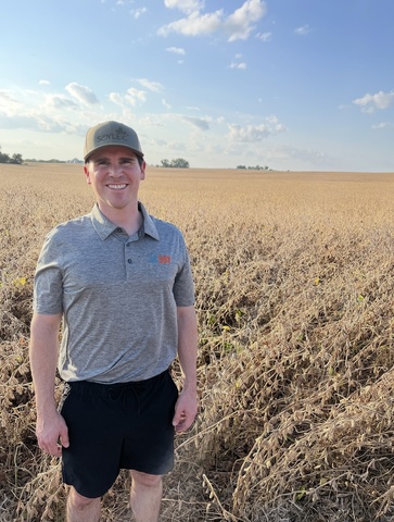 This is a photo of Paul Spooner standing next to a field of soybeans.