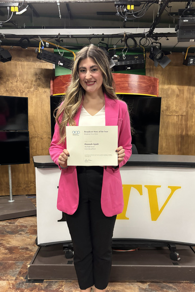 Image of Hannah Fideli holding award.