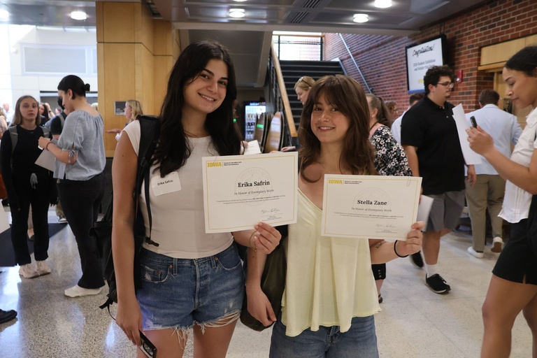 This is a photo of two SJMC Students presenting their scholarships at the 2026 Student Exhibition