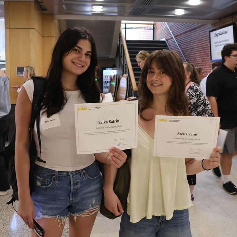 This is a photo of two SJMC Students presenting their scholarships at the 2026 Student Exhibition