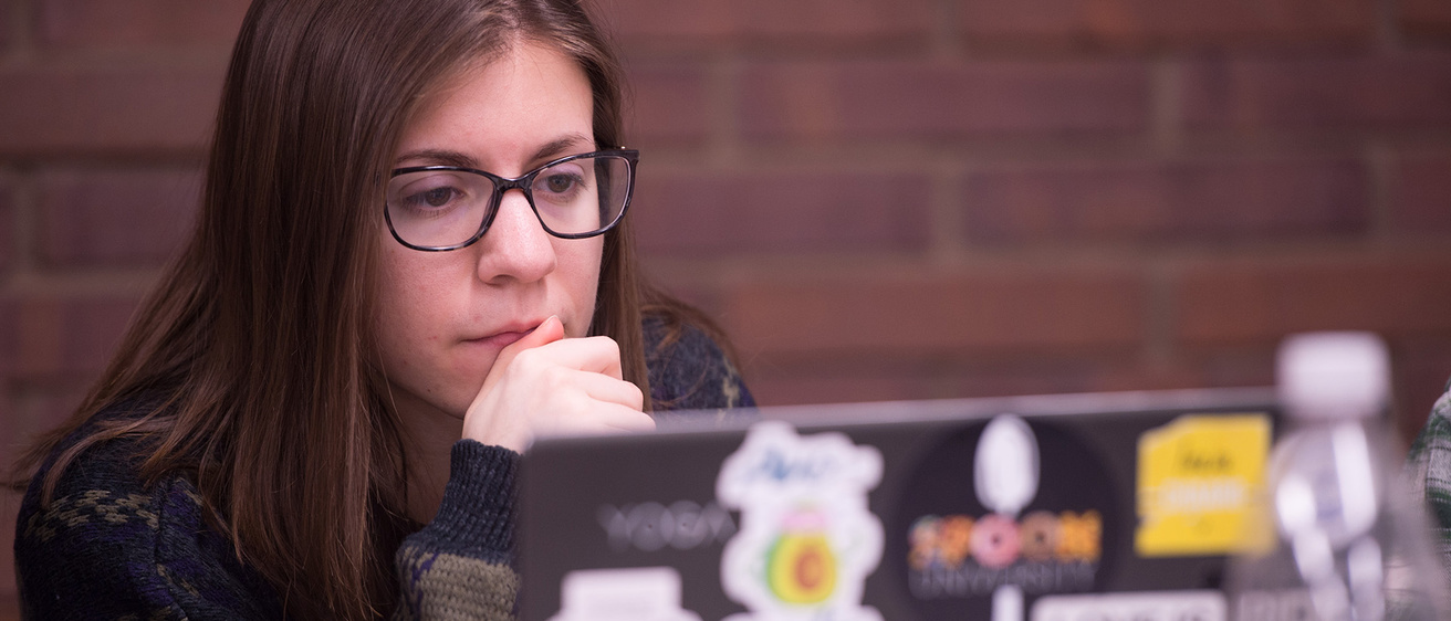 a woman looking intently at a laptop screen