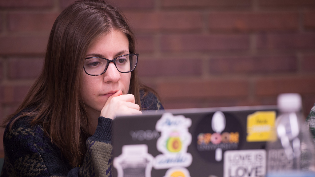a woman looking intently at a laptop screen
